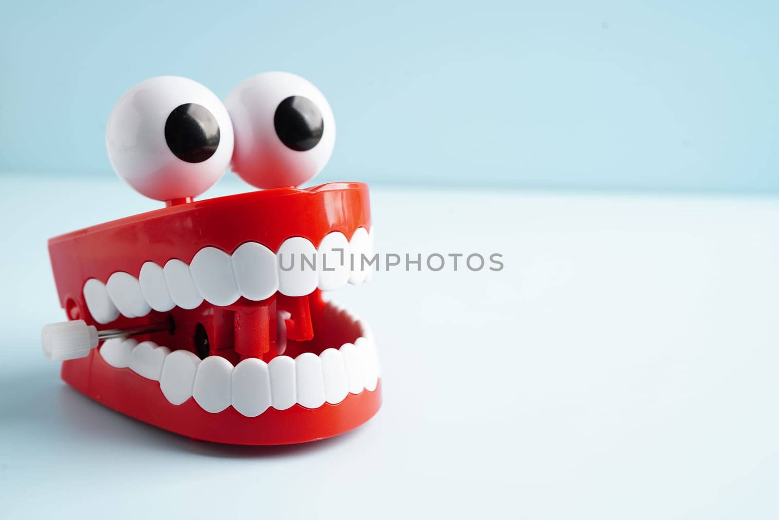 Funny red teeth with eye toy denture model for dental health care.