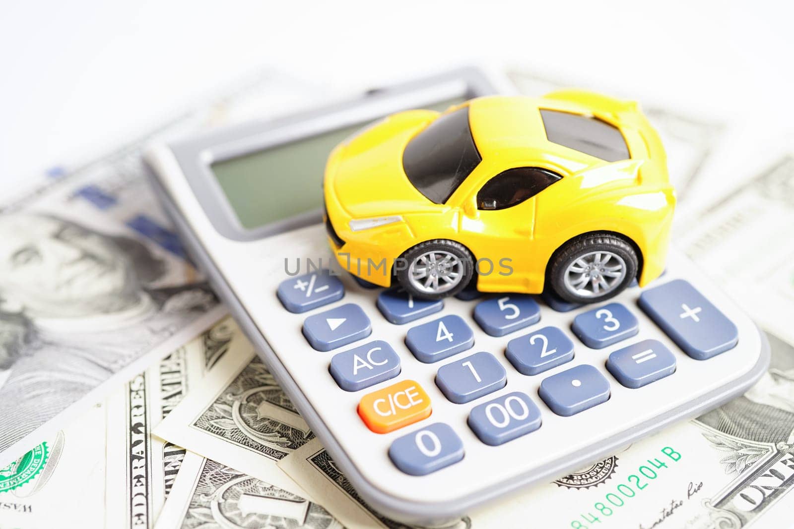 Bangkok, Thailand November 18, 2023 Car on banknote money with calculator, buying or insurance concept.