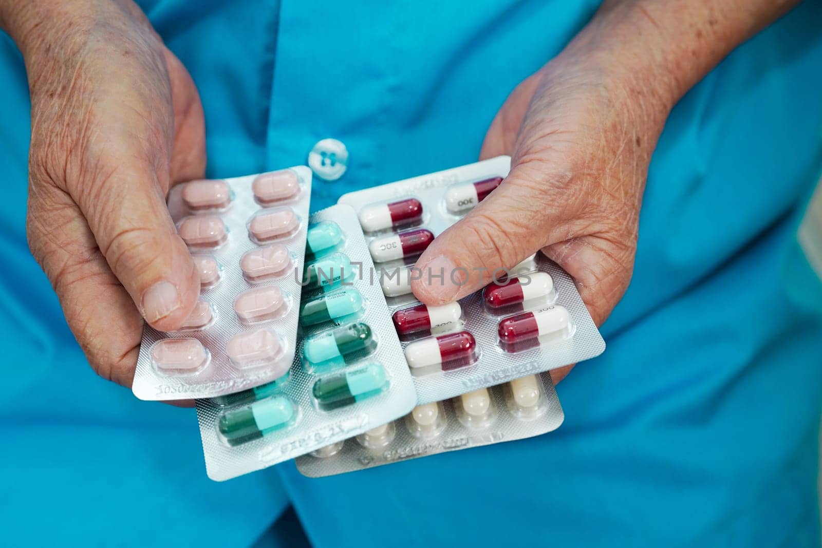 Asian elderly woman holding pill drug in hand, strong healthy medical concept.