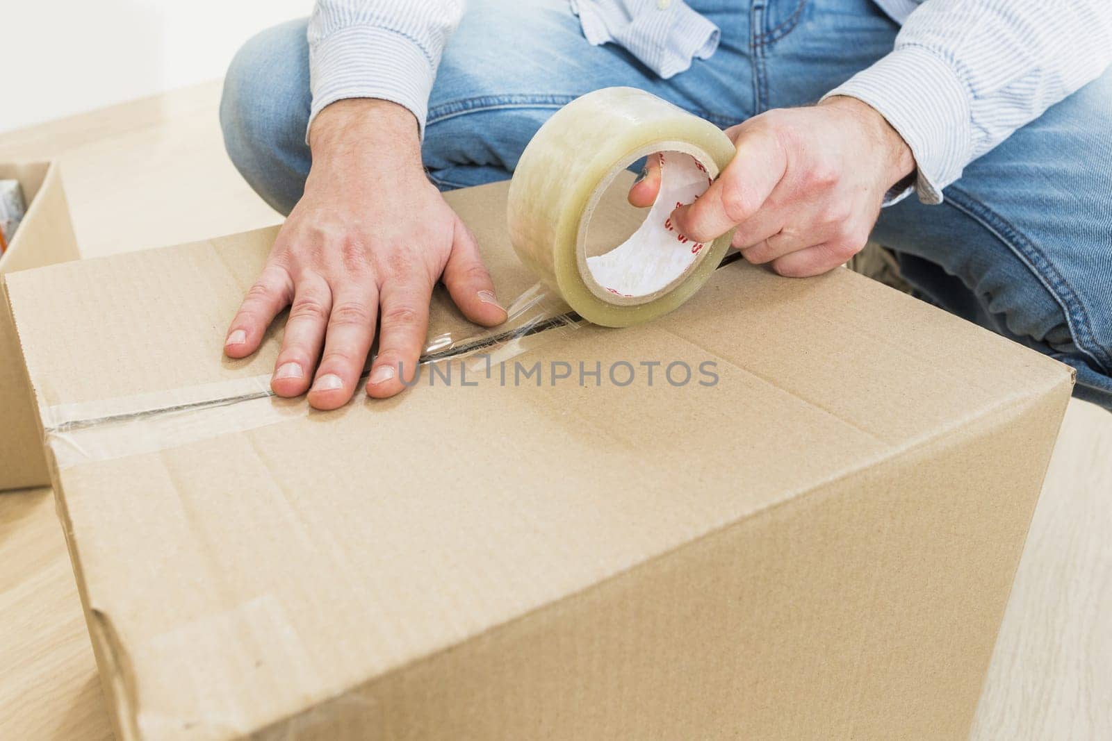 young man sealing cardboard box with tape big moving. Resolution and high quality beautiful photo