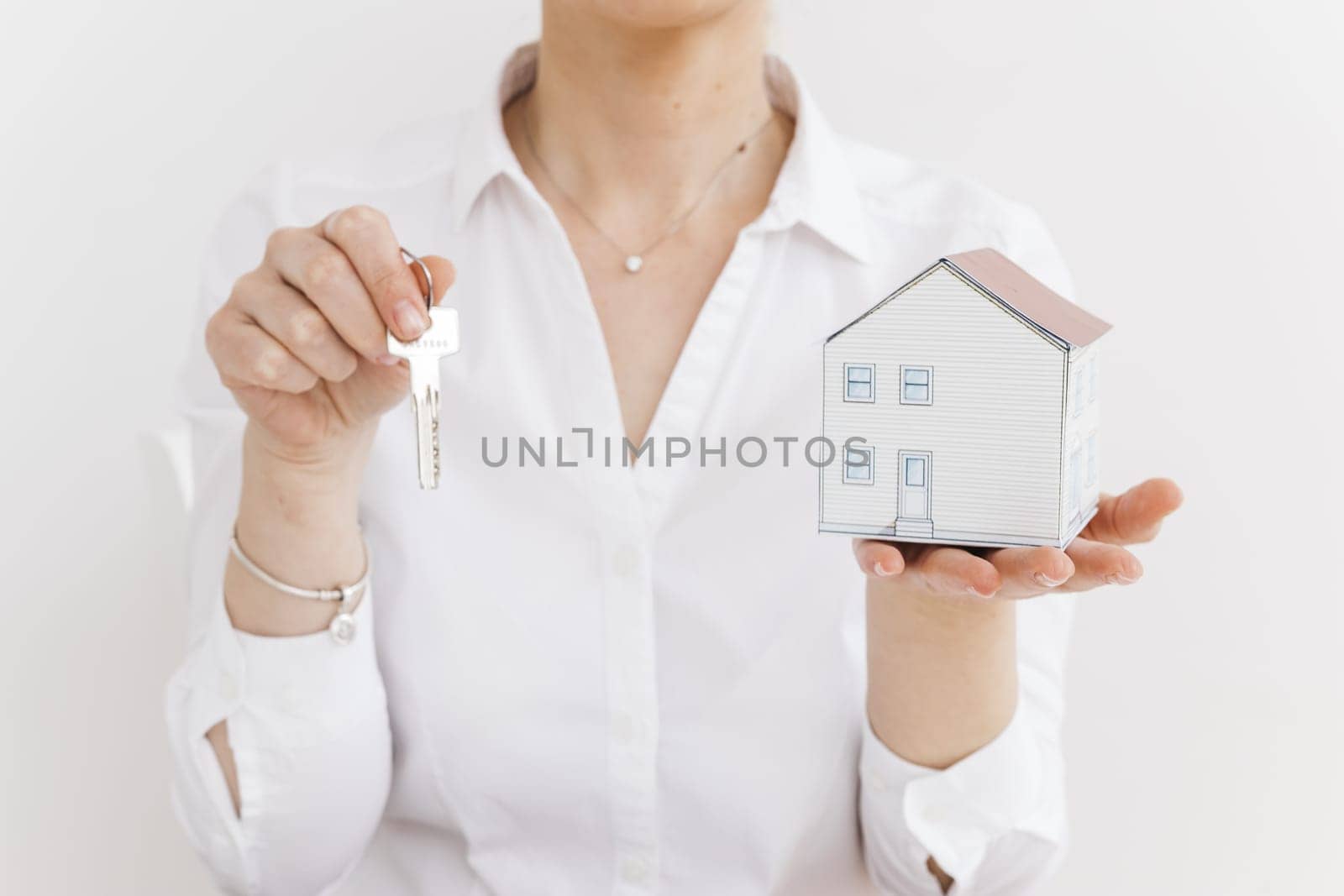 woman holding key small paper house white background. Resolution and high quality beautiful photo