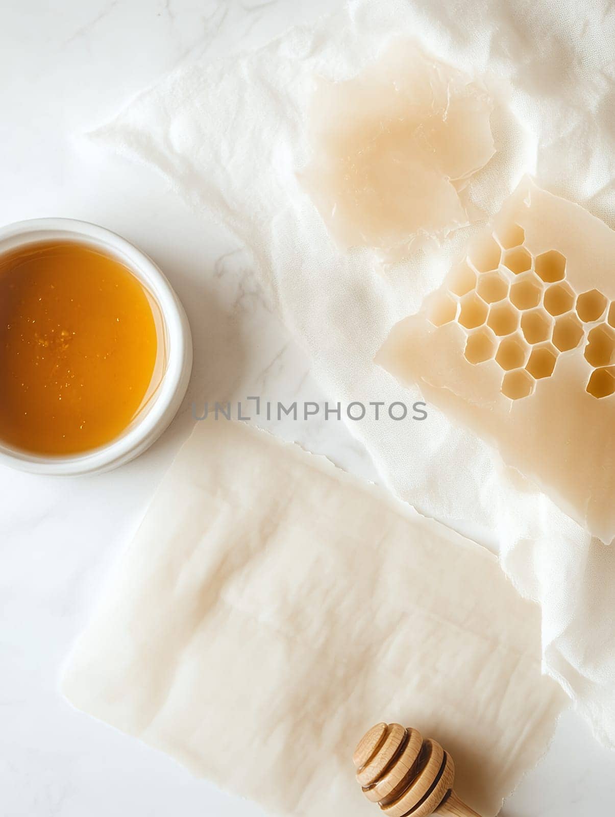 Flatlay of beeswax and honey on a white cloth, showcasing natural elements for skincare.