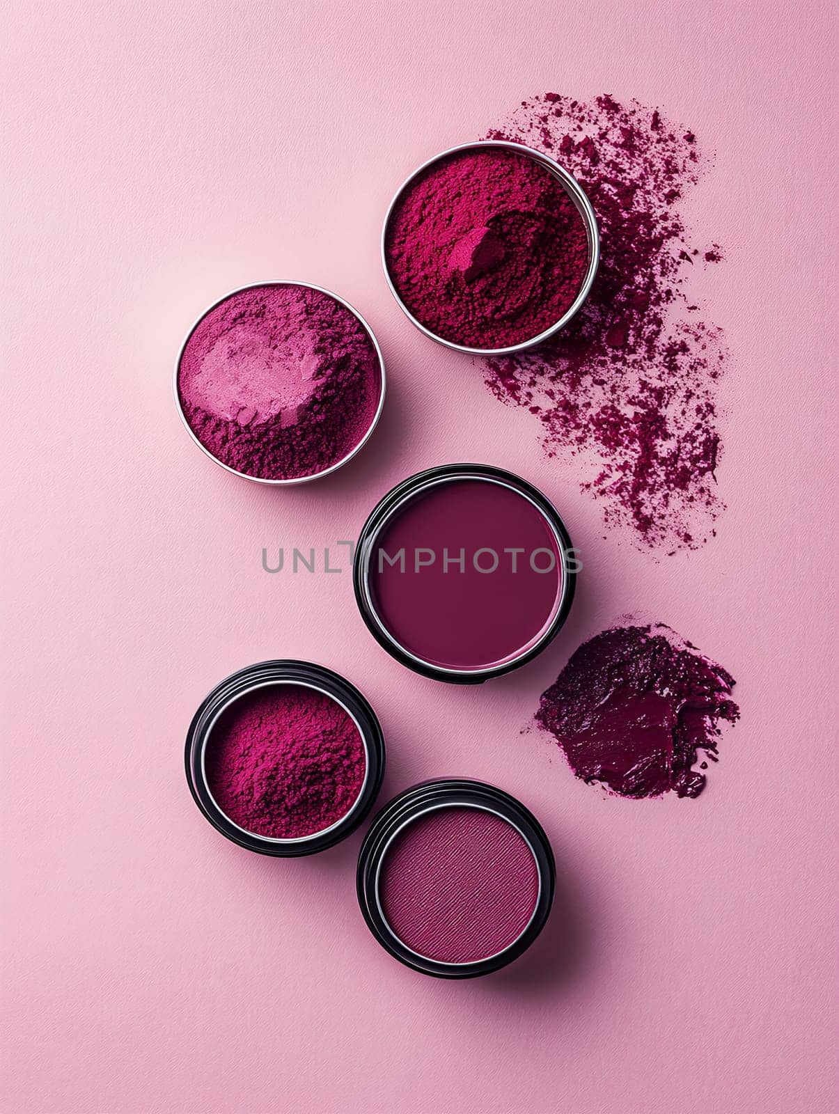 Bold pink makeup powders in small containers, spread artistically on a pink background, ideal for beauty and cosmetics.