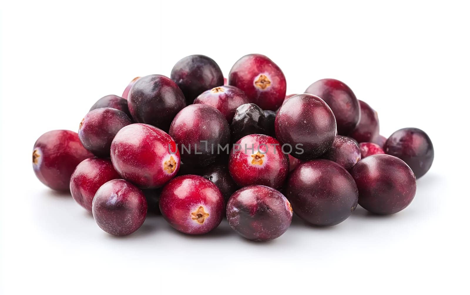 A pile of fresh cranberries on a white surface, showcasing their shiny and vibrant appearance.