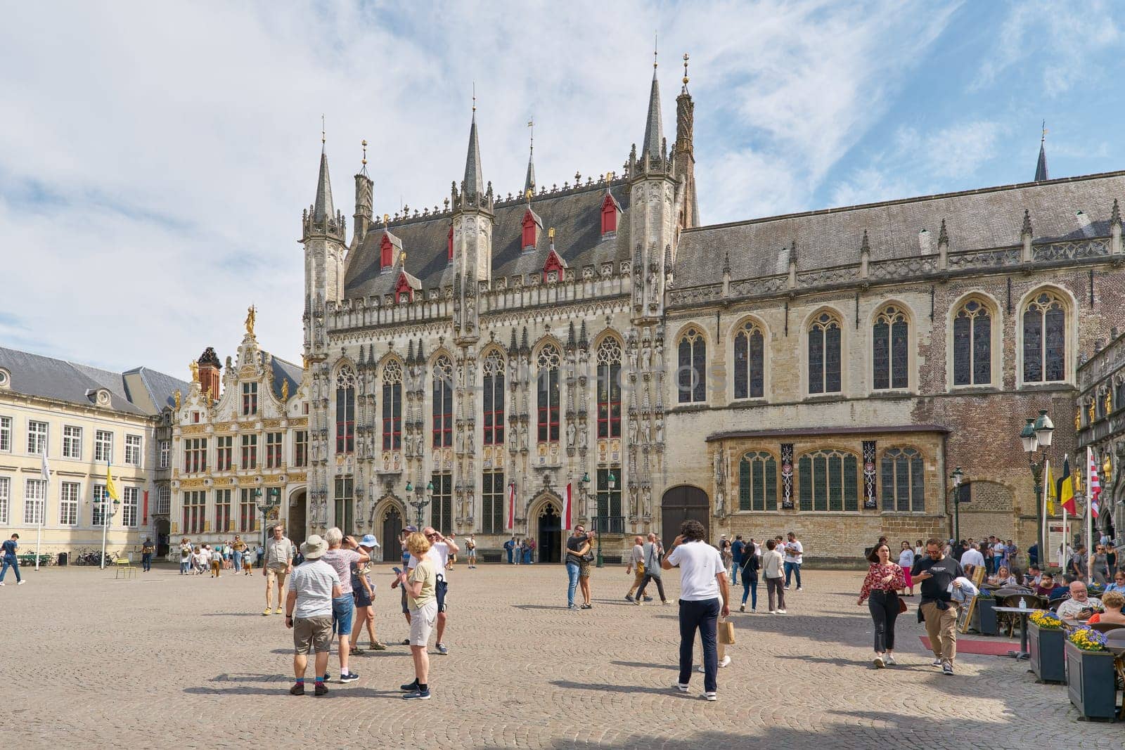 Tourists in front of the historic town hall Stadhuis from 1376 in the old town of Bruges in Belgium