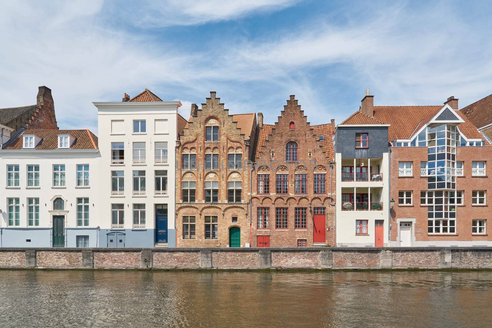 Combination of historic and modern residential buildings on the banks of a canal in the old town of Bruges in Belgium