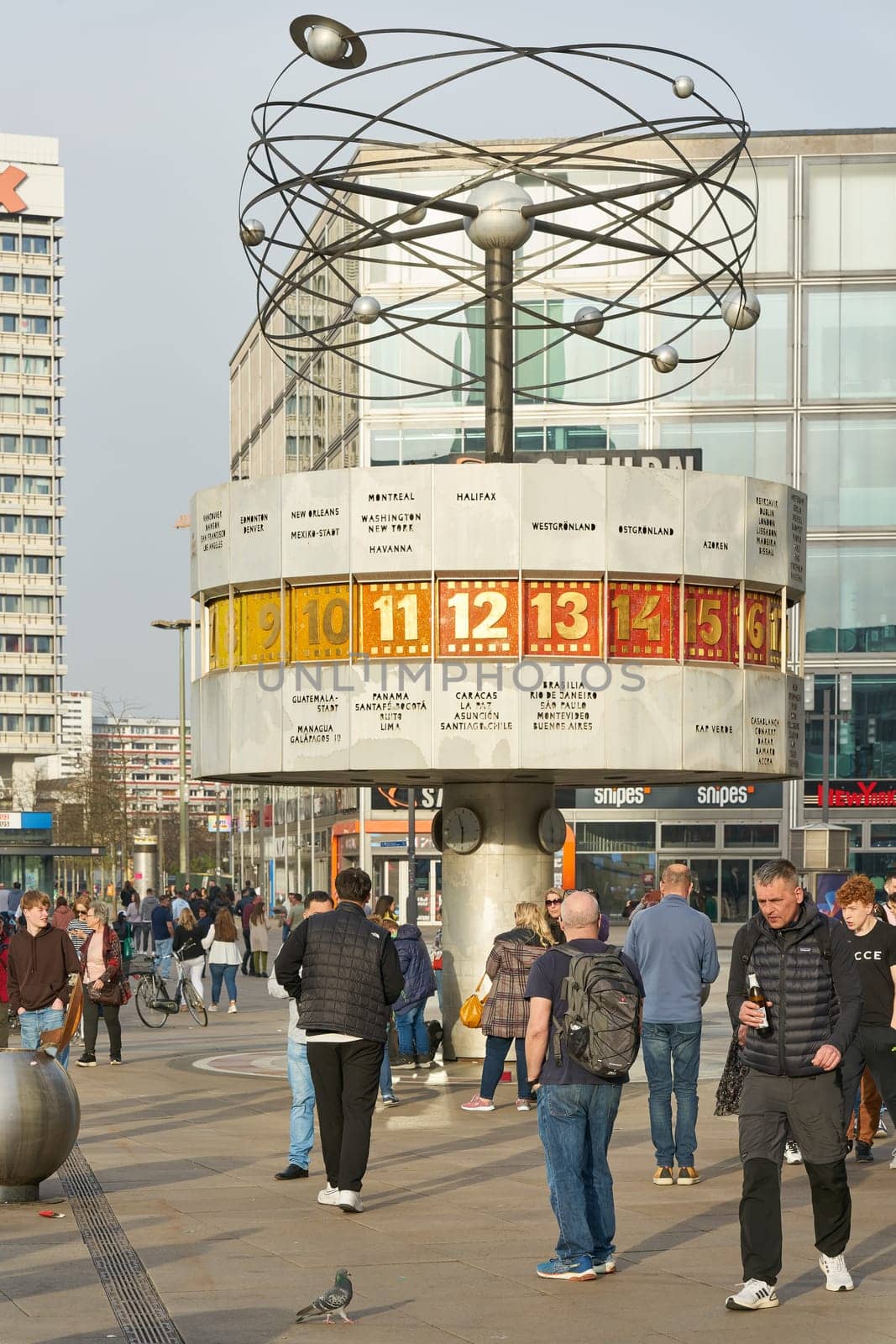 Scene with tourists and residents at the Weltzeituhr, World Time Clock in Berlin-Mitte in Germany
