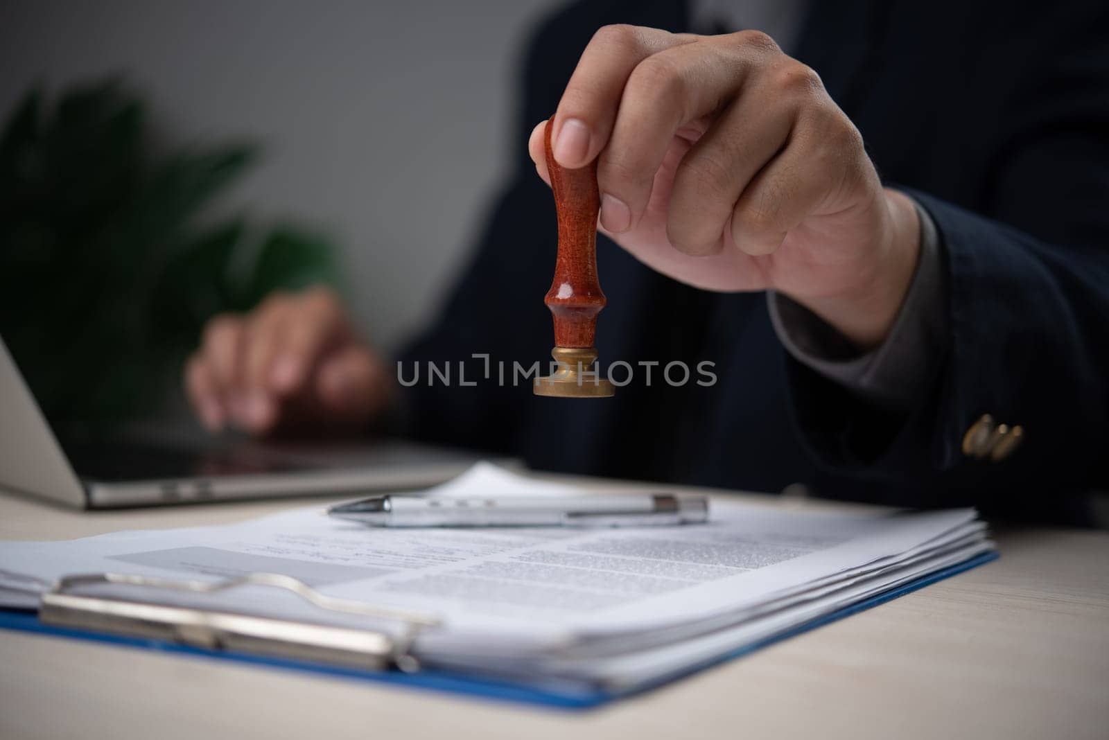 Confident Businessman Stamping Official Document in Modern Office Legal Approval Process