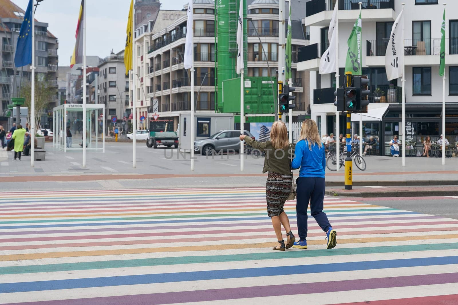Crosswalk in rainbow colors with passers-by in the Belgian coastal town of Blankenberge in Flanders on the North Sea