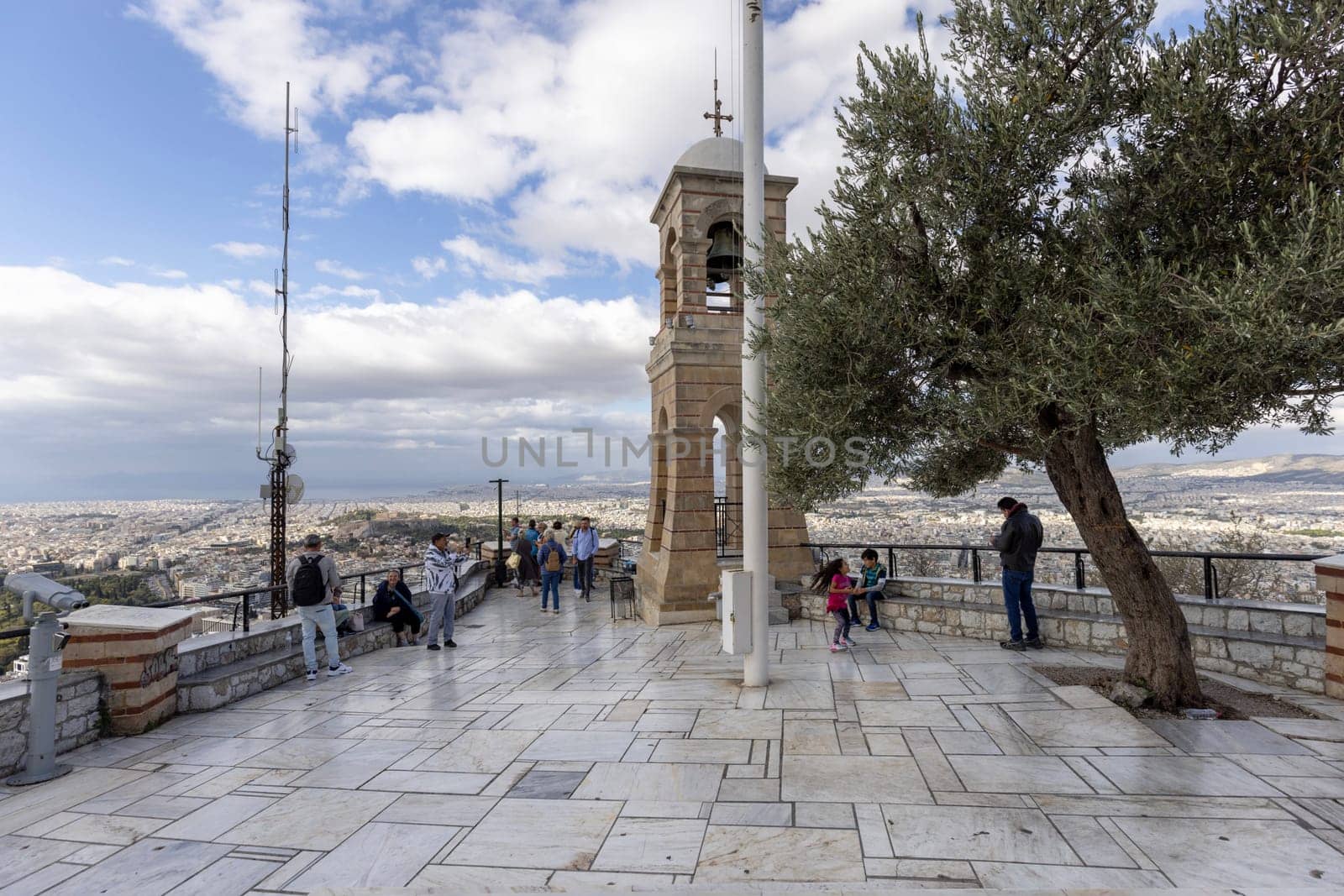 Athens, Greece - October 18, 2022: Observation deck on top of Mount Lycabettus with bell tower of Saint George's chapel, aerial view of the city.Peak is the highest point in Central Athens