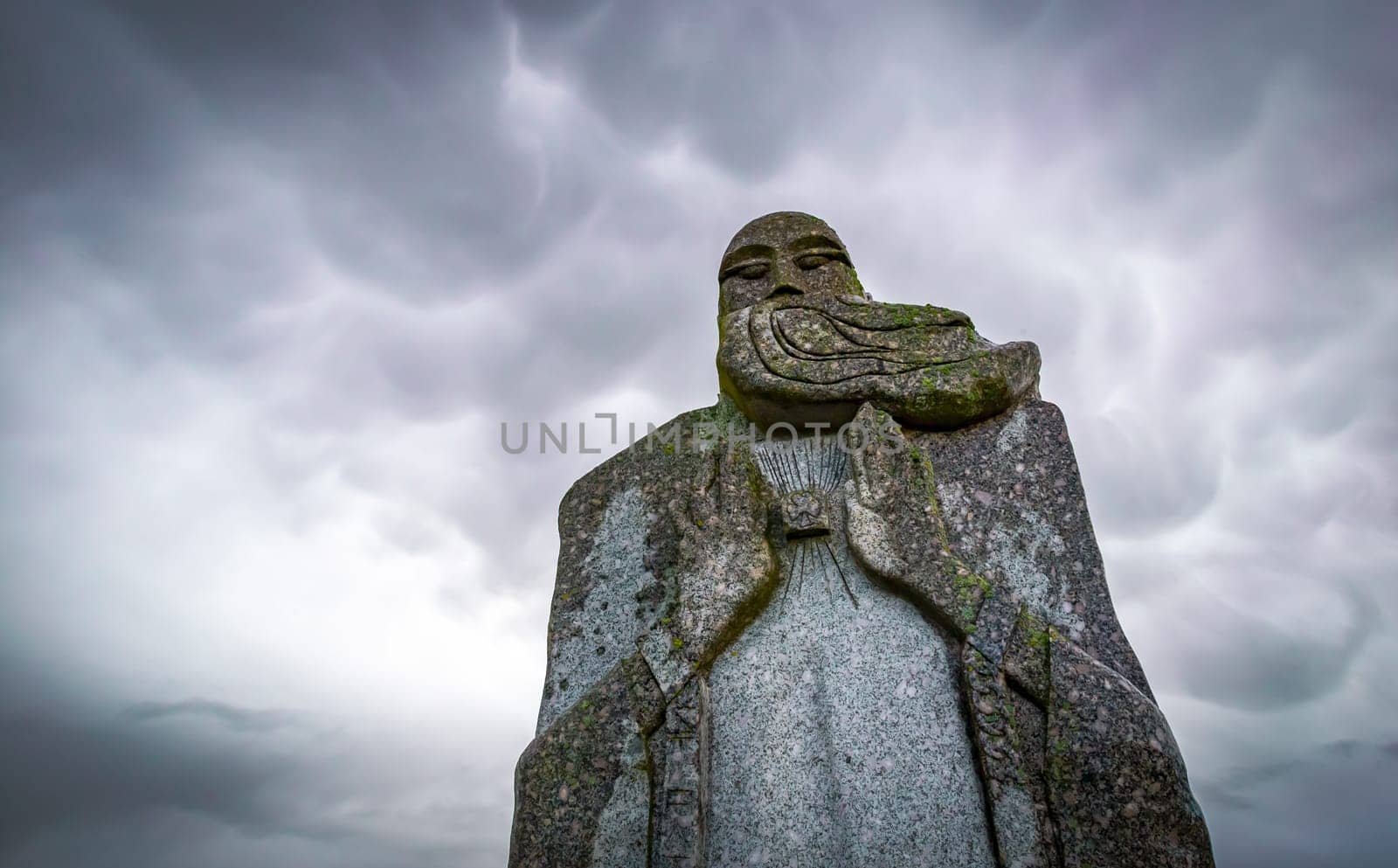 Carnoët, Bretagne, France - March 22, 2017: Detail of granite statue in the Valley of the Saints in a dramatic cloudy atmosphere