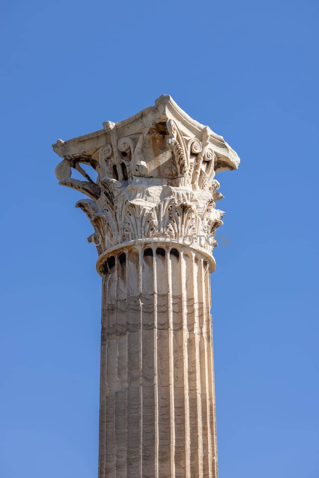 Athens, Greece - October 19, 2022: Decorative corinthian column in remains of Temple of Olympian Zeus on a background of blue sky.