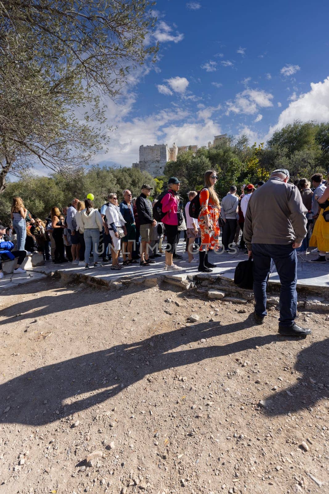 Athens, Greece - October 17, 2022: Group of tourists waiting in line at the ticket counter to enter the Acropolis Hill
