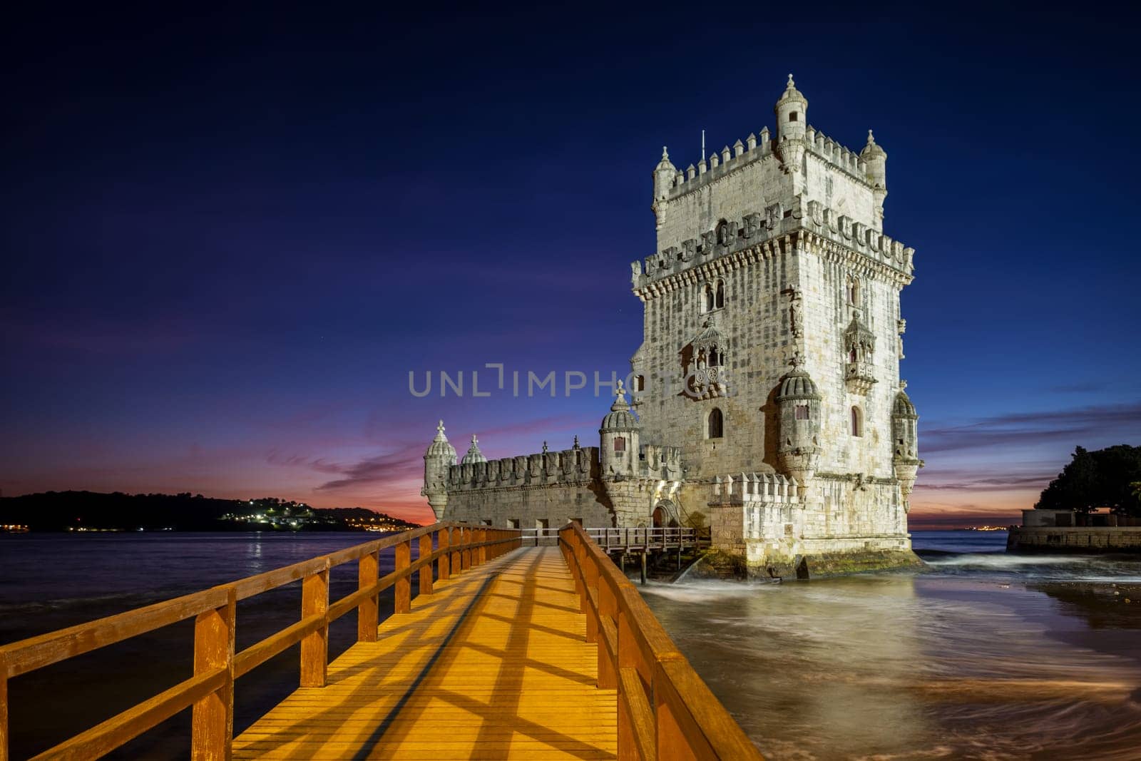 Belem Tower or Tower of St Vincent - famous tourist landmark of Lisboa and tourism attraction - on the bank of the Tagus River (Tejo) after sunset in dusk twilight with dramatic sky. Lisbon, Portugal
