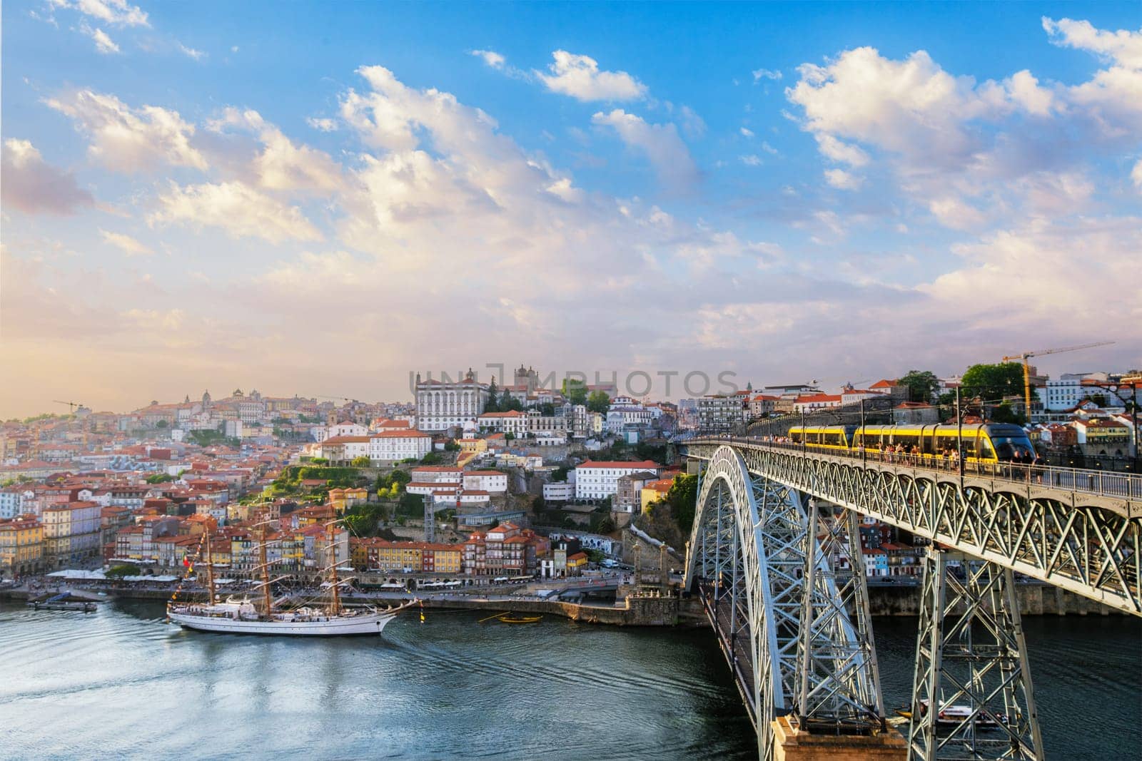 View of Porto city and Douro river and Dom Luis bridge I with tram from famous tourist viewpoint Miradouro do Jardim do Morro on sunset. Porto, Vila Nova de Gaia, Portugal