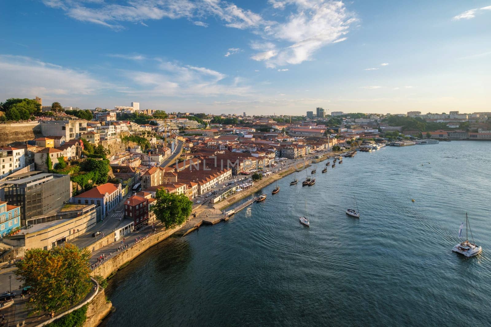 View of Vila Nova de Gaia city and Douro river with tourist boats on sunset. Porto, , Portugal
