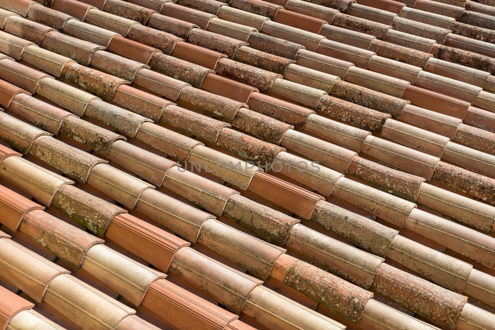 Roof tiles background. The roof tiles show their age. Seen before roofing renovation.