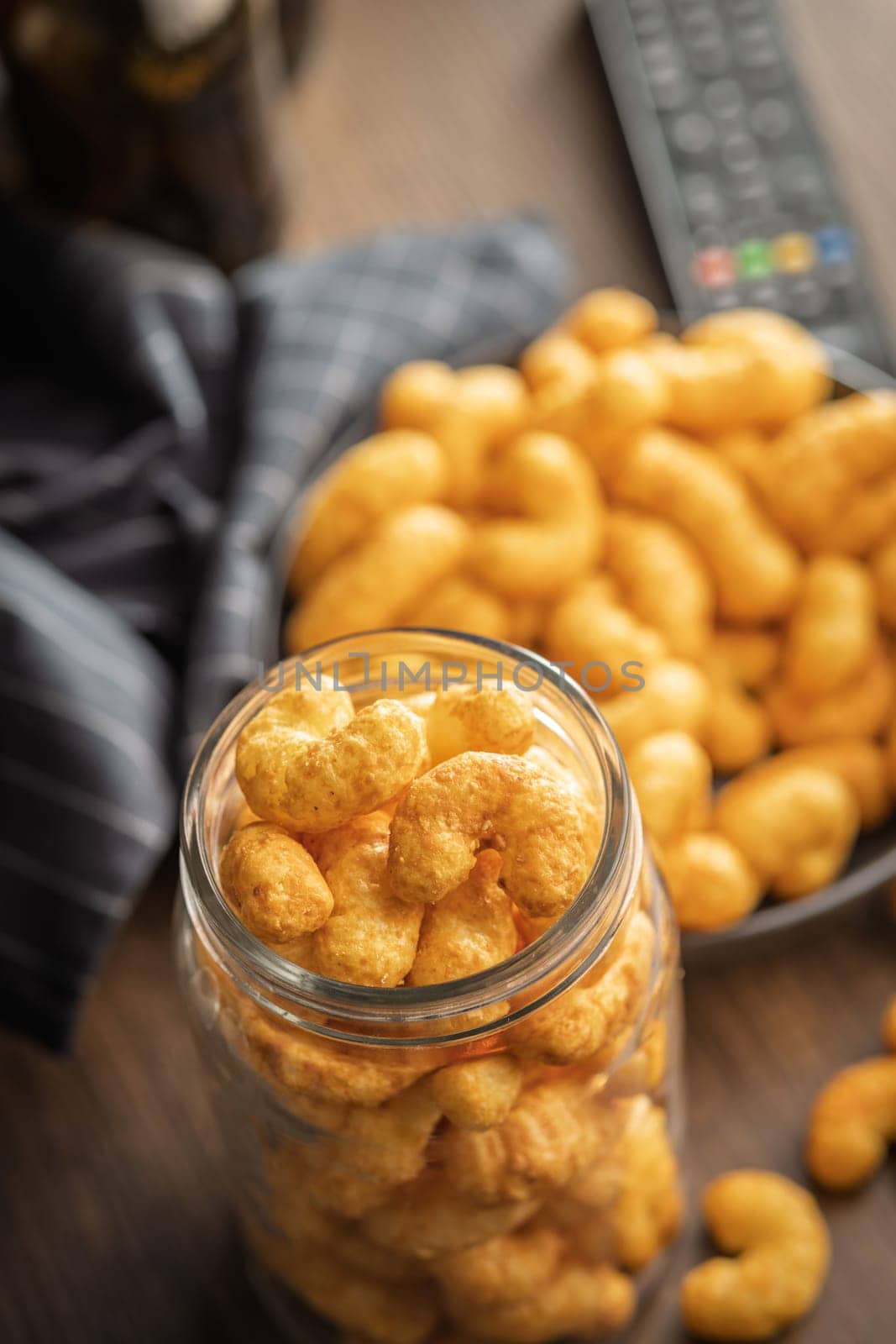 Puffed crispy Peanut flips in jar on a wooden table.