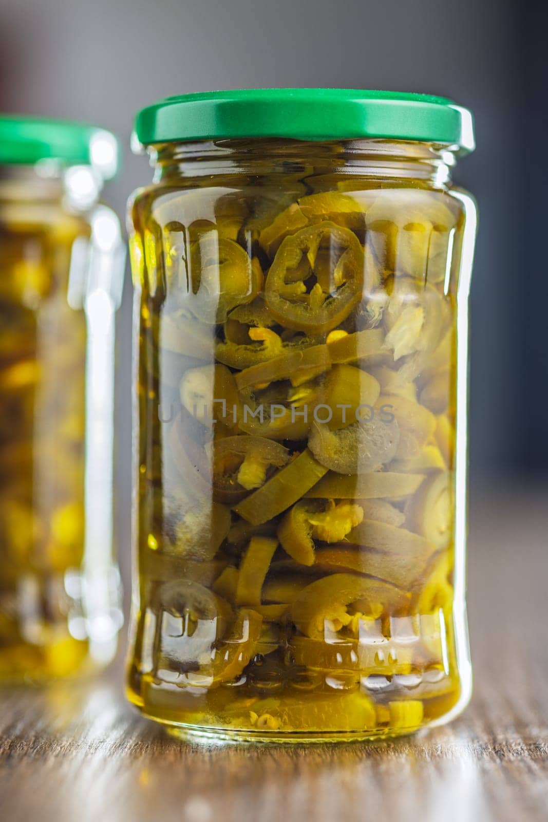 Pickled sliced jalapeno peppers on a wooden table.