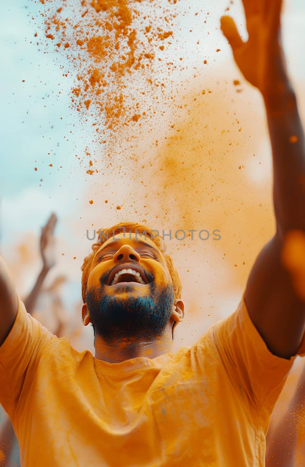 A joyful person celebrates with vibrant orange color powder in the air, capturing the essence of a lively festival.