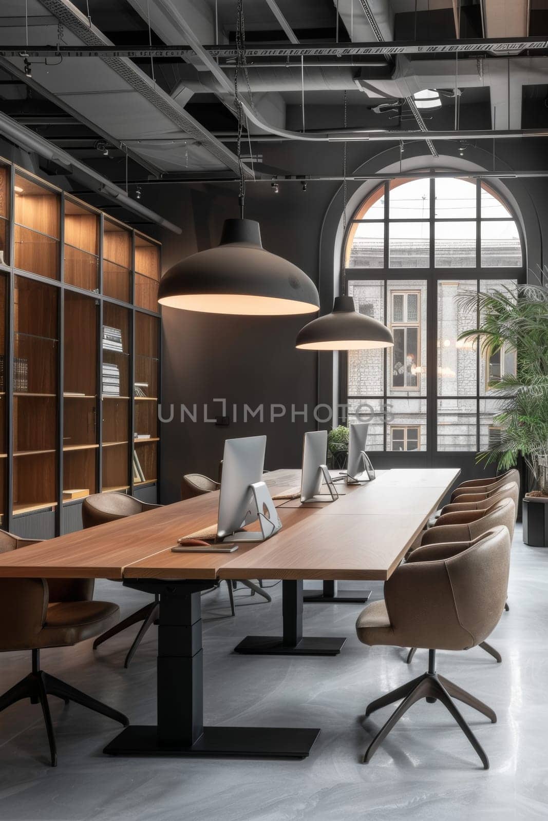 A modern office space with a large wooden table and several chairs. The room is well lit and has a professional atmosphere