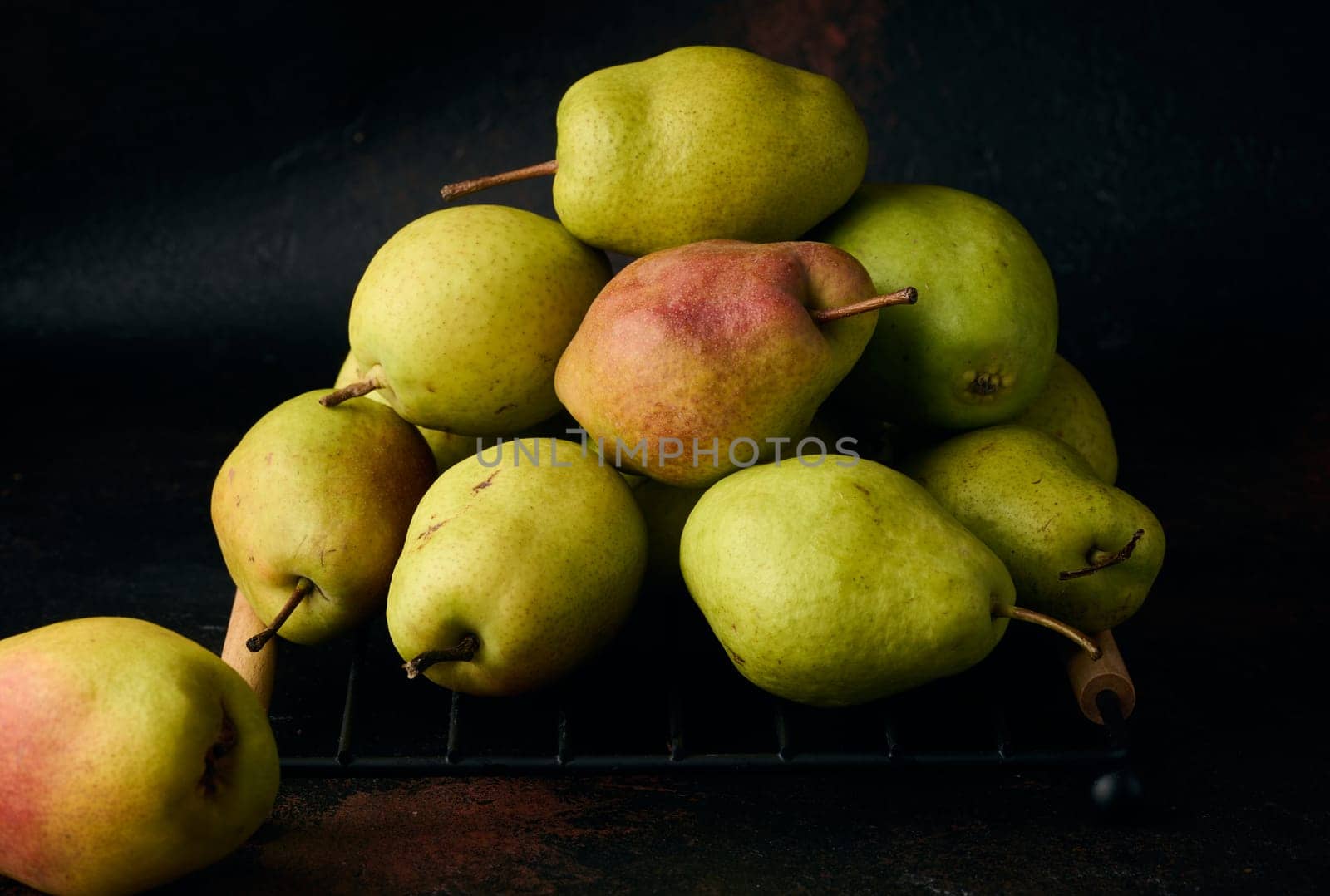 A pile of green pears on a brown background