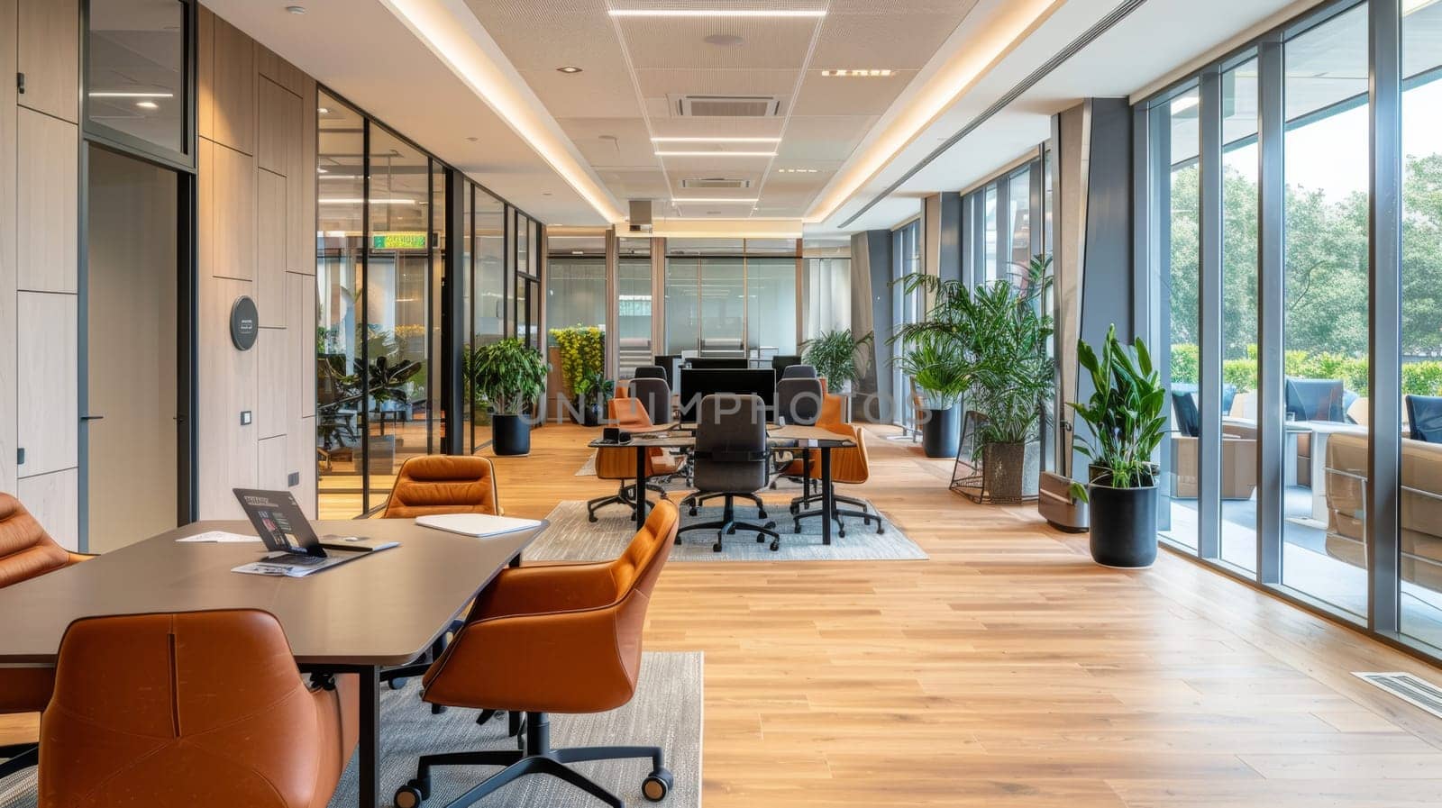A large open office space with a lot of plants and a few chairs. The room is well lit and has a modern feel