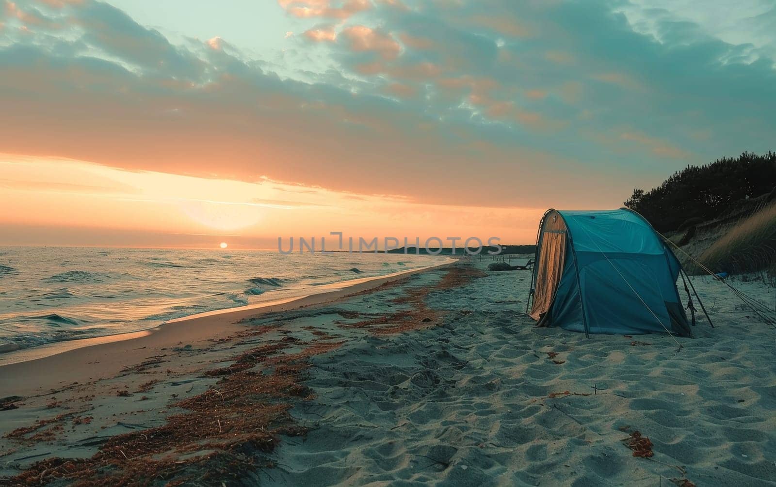 A tranquil beach camping scene at sunset with a colorful sky, featuring a tent overlooking the serene ocean waves