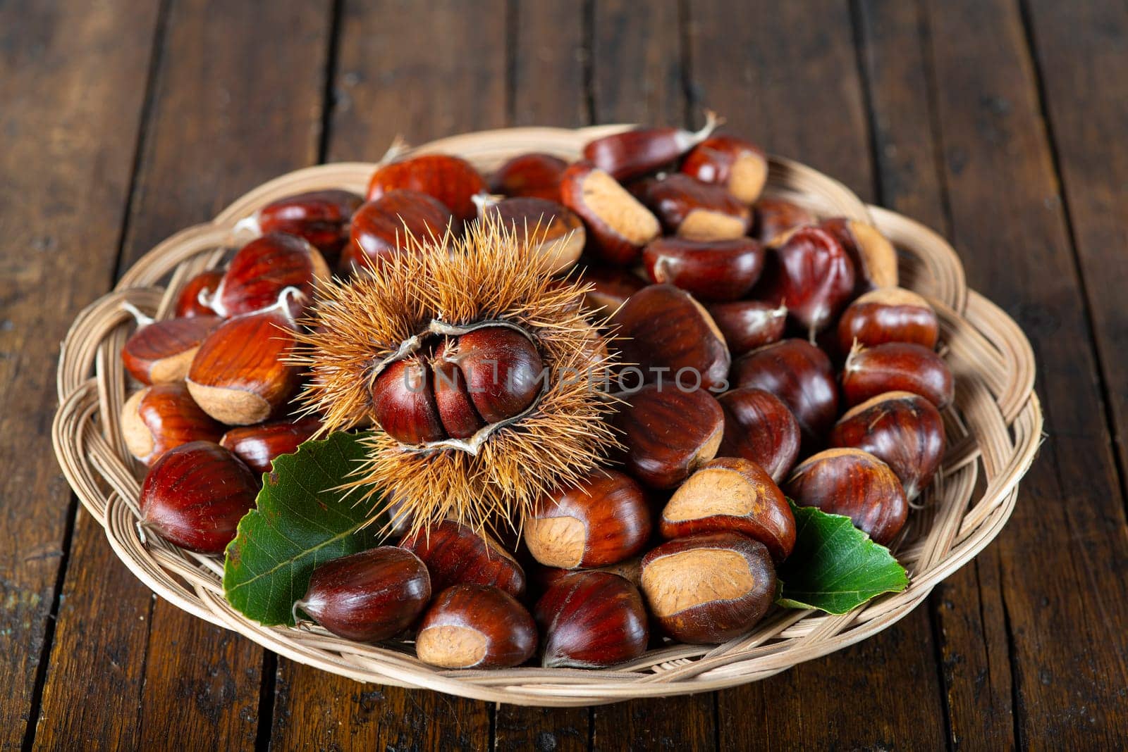 Chestnut with leaves on a wooden background