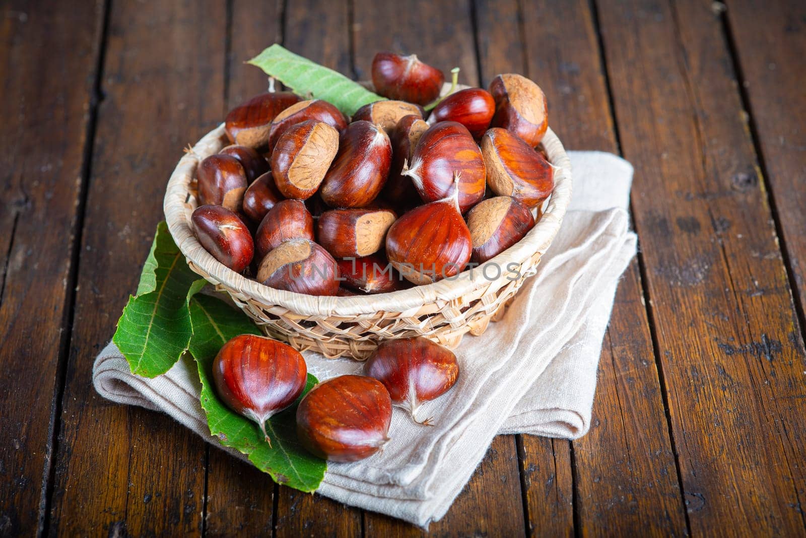 Chestnut with leaves on a wooden background