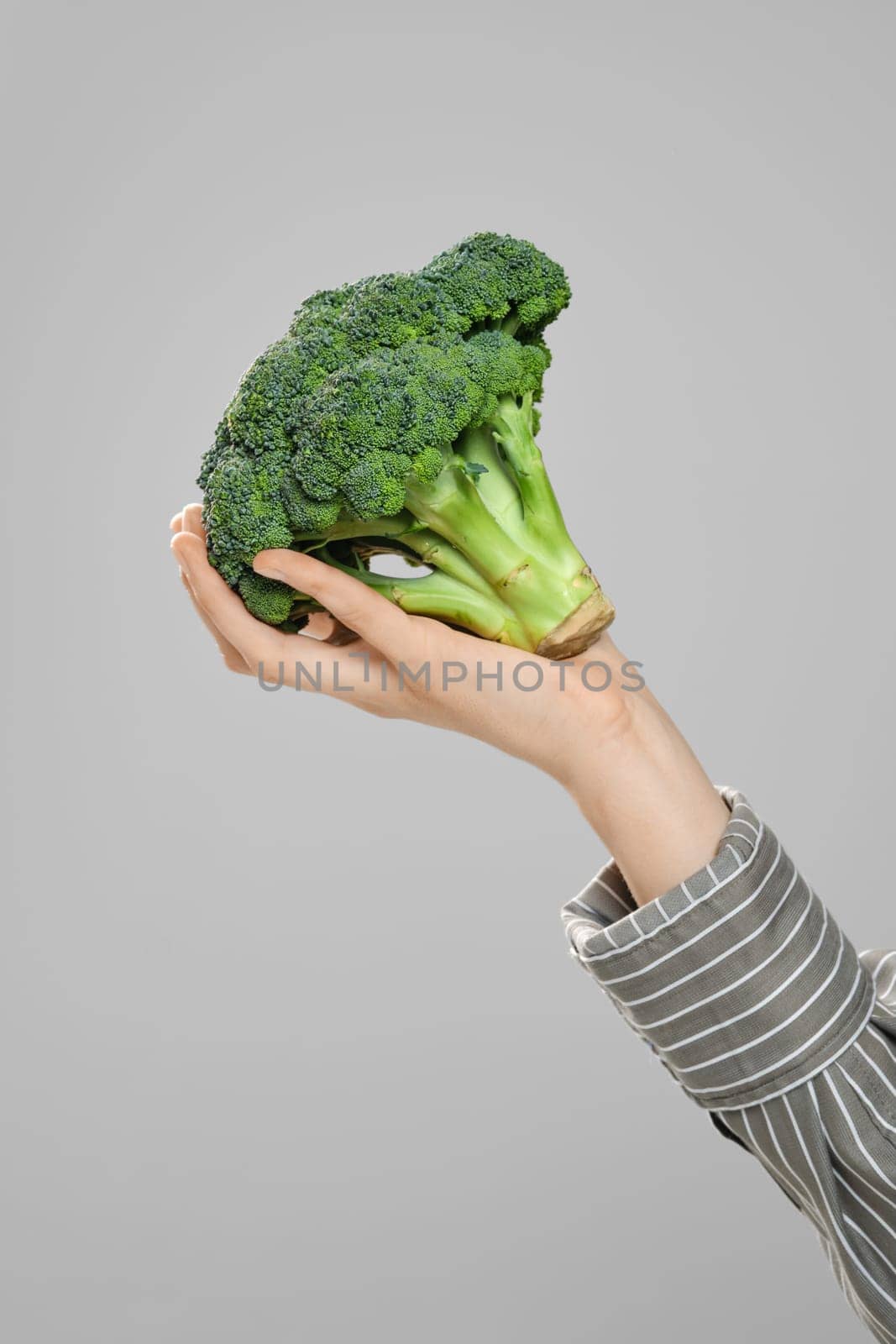 Close up view of female hand with fresh broccoli
