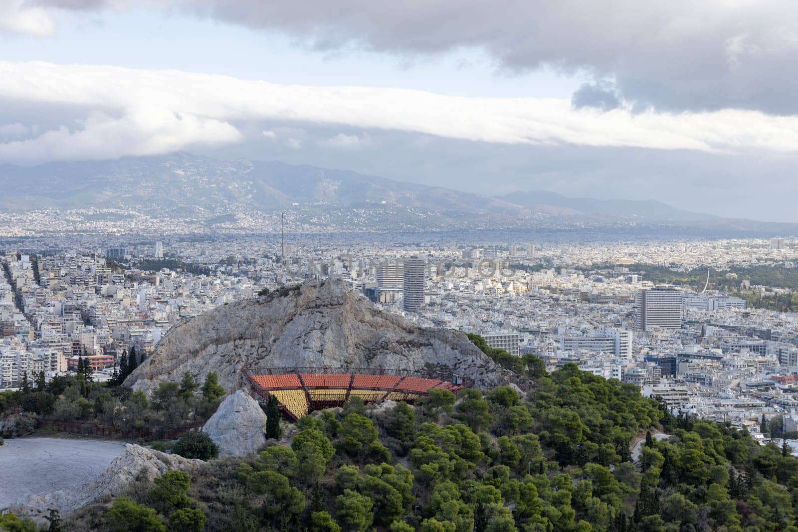Athens, Greece - October 18, 2022: View from observation deck of Mount Lycabettus of open-air amphitheater, Lycabettus Theatre. Panorama of the city in the distance