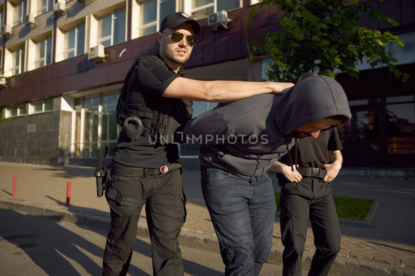 Two police officers providing arrest of criminal in act on city street. Final stage of patrol and operational development