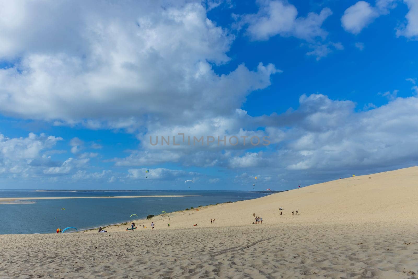 Dune of Pilat, France - August 14, 2024: People paragliding at the Great Dune of Pilat, Arcachon Basin, Nouvelle Aquitaine, France.