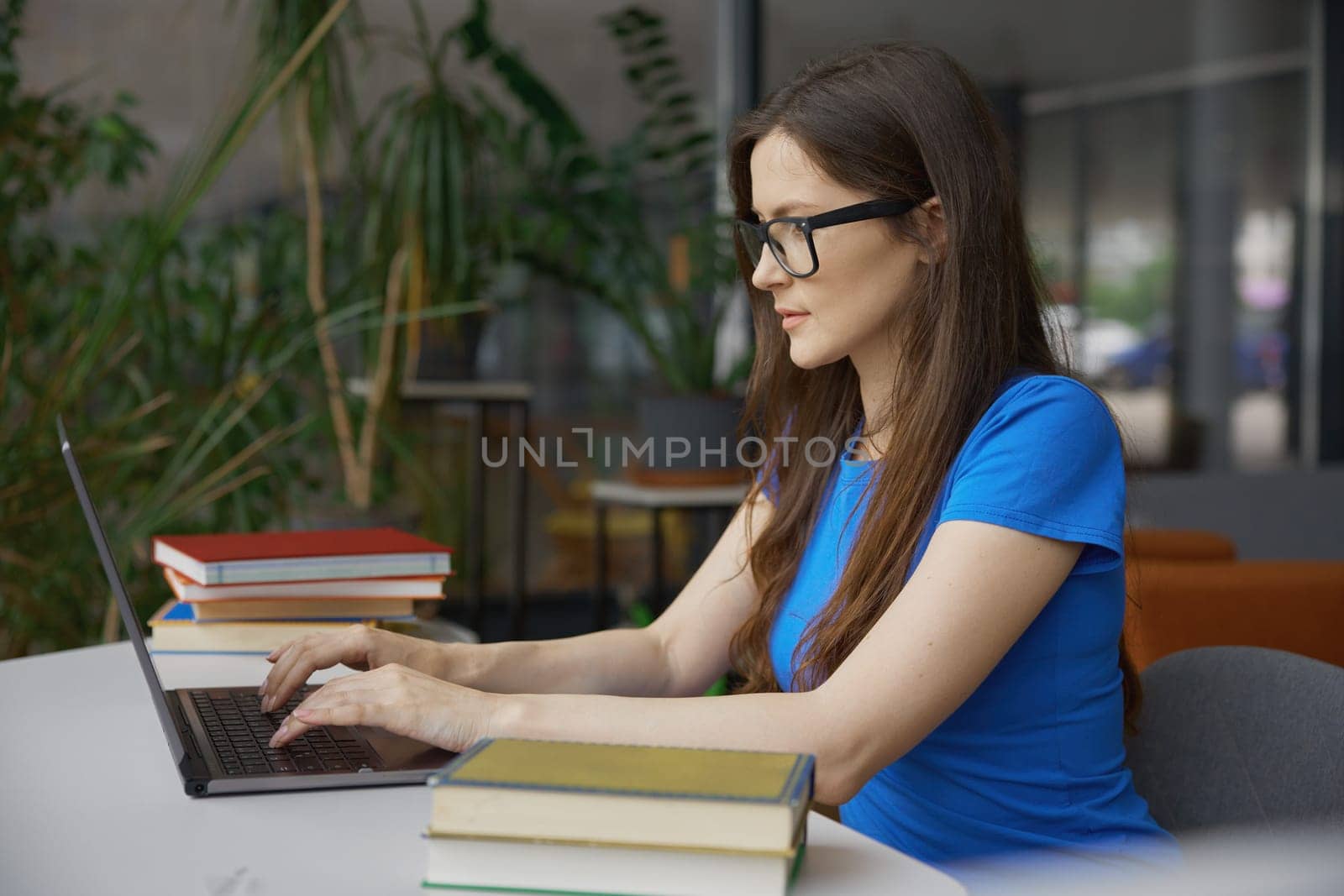 Young woman student studying or doing online research on internet using laptop computer in library