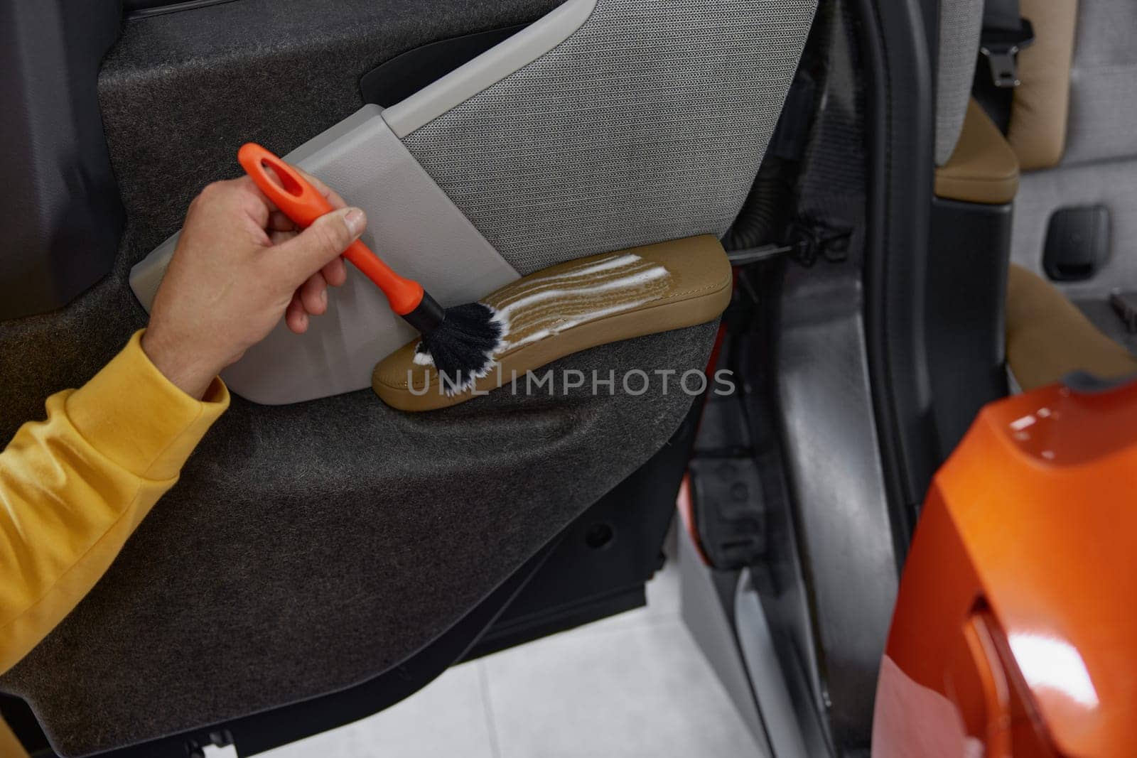 Man master working at car wash service providing professional safety leather dirt cleansing and treatment procedure