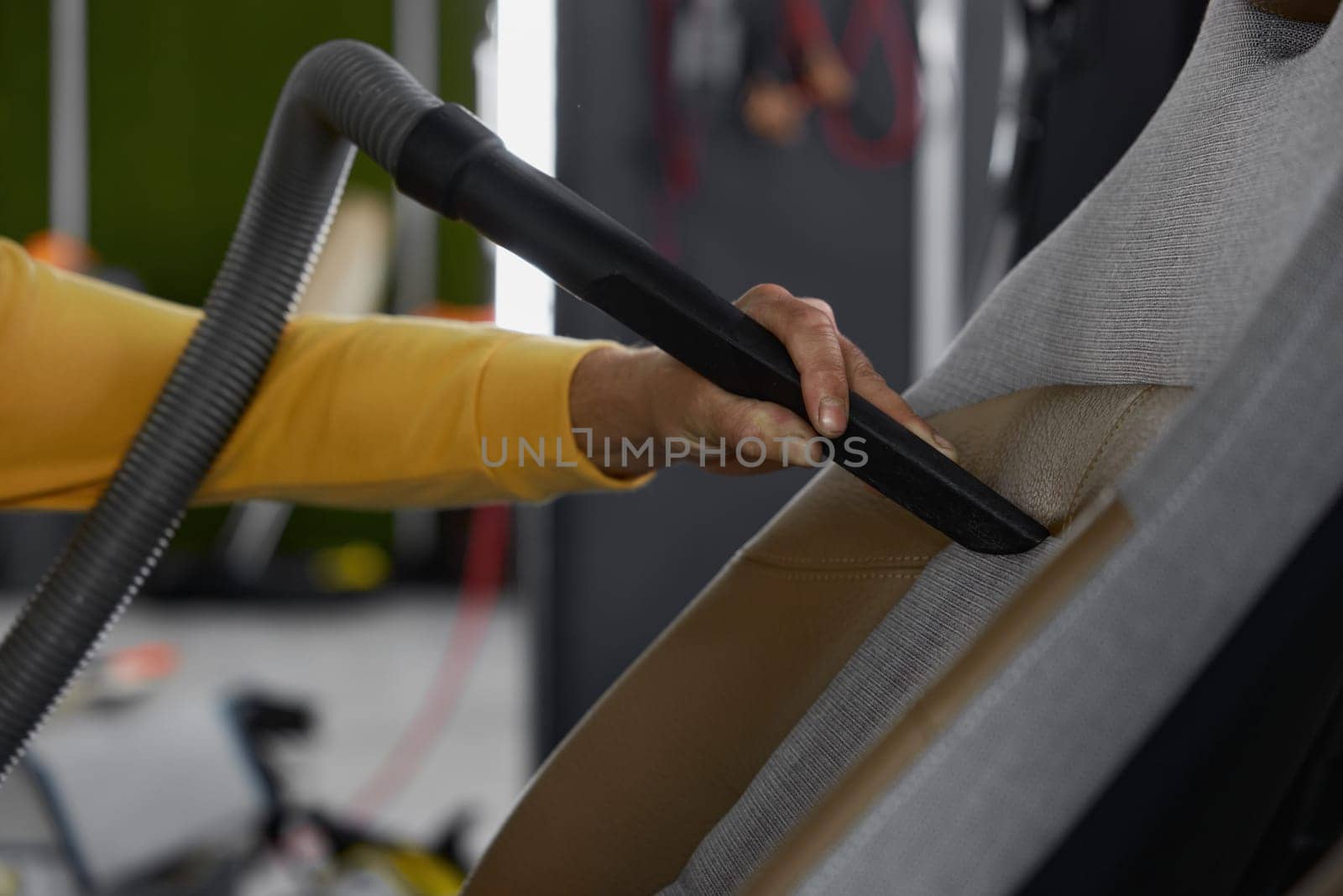 Closeup of vacuuming car interior from dust using professional equipment. Car-wash service concept