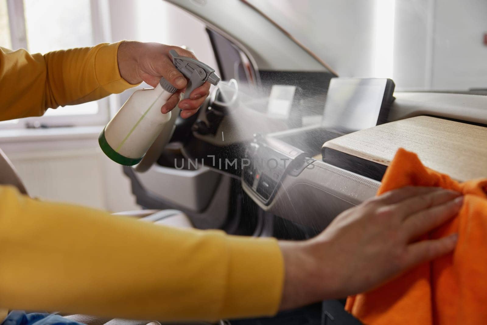 Professional service master working at car wash service providing professional safety leather dirt cleansing and treatment procedure