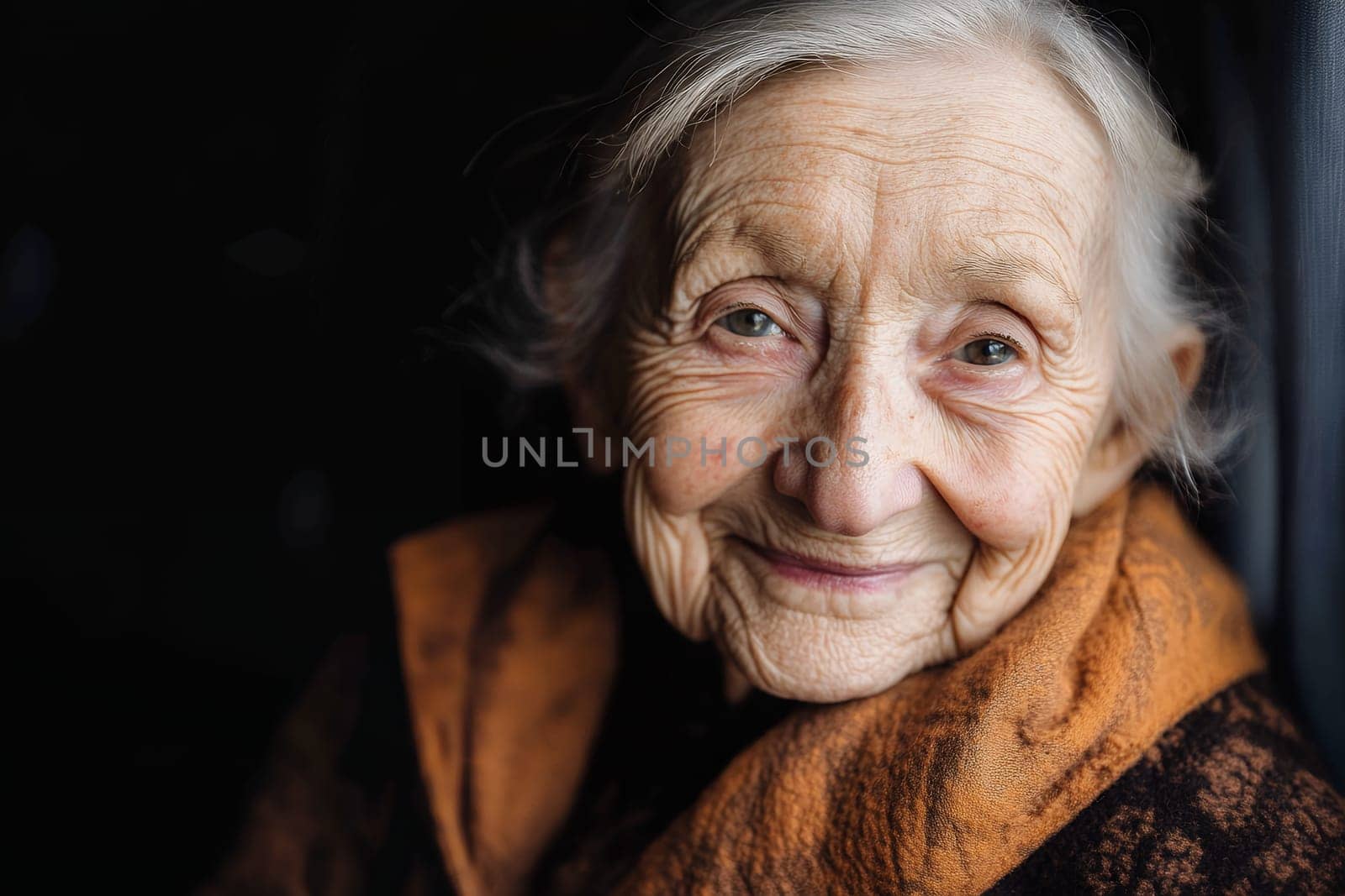 A gentle smile lights up the face of an elderly woman, reflecting warmth and kindness.