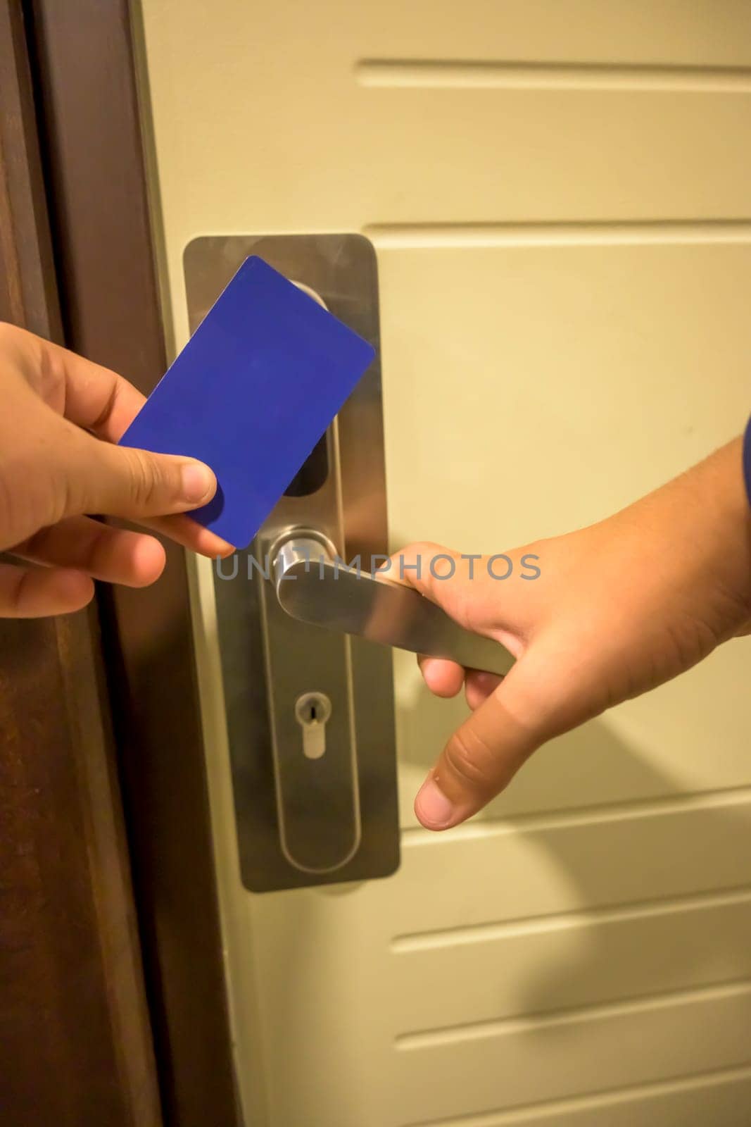 A hand inserting a blue card key into a modern hotel door lock, key electronic lock, hotel room, holidays in mallorca, spain