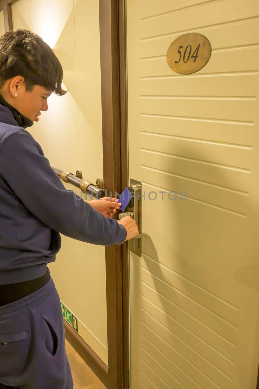 Latin young men opens a door with a keycard in a hallway, key electronic lock, hotel room, holidays in mallorca, spain.