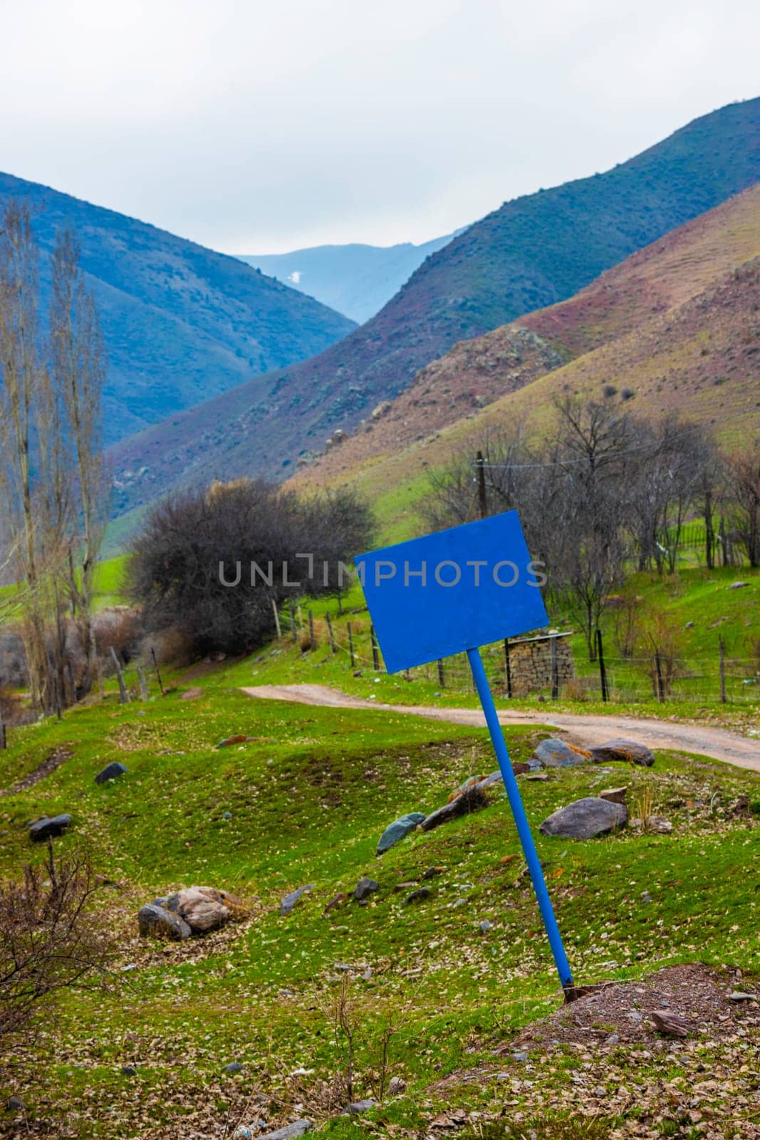 a crooked blank blue sign on a steel pole at the entrance to mountain gorge