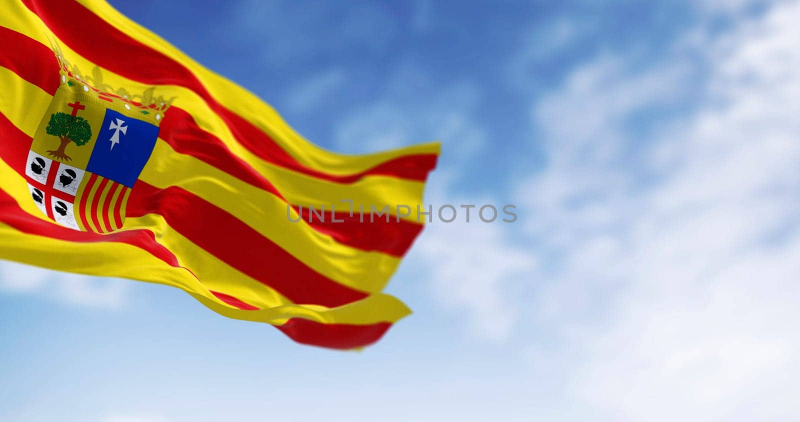 Flag of Aragon waving in the wind on a clear day. Spanish region. 3d illustration render. Selective focus