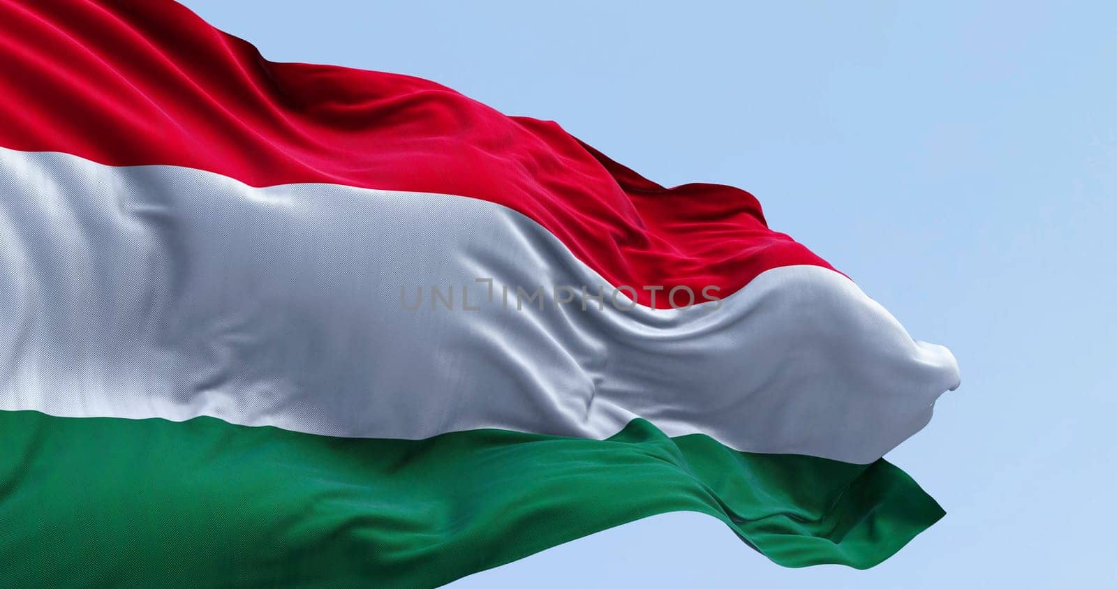 Close-up of Hungary national flag waving in the wind on a clear day. Horizontal striped flag of red, white and green. 3d illustration render. Fluttering fabric