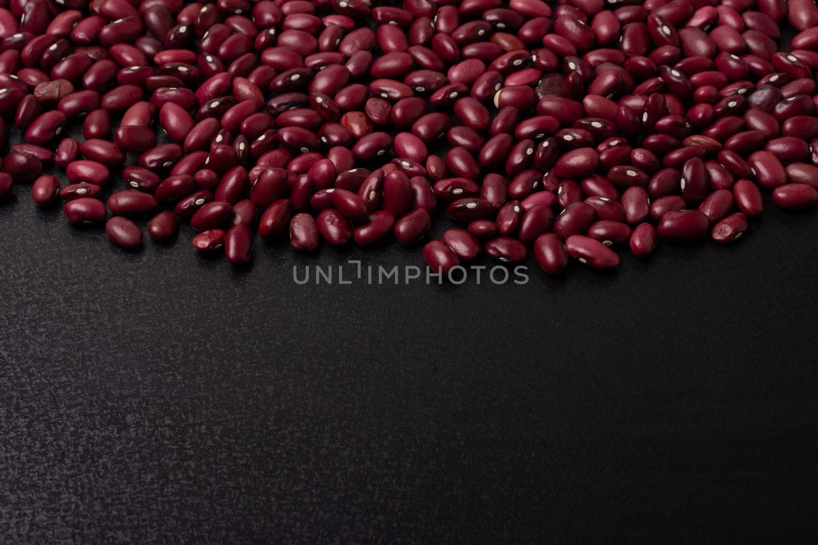 Red beans on a black background, top viewpoint