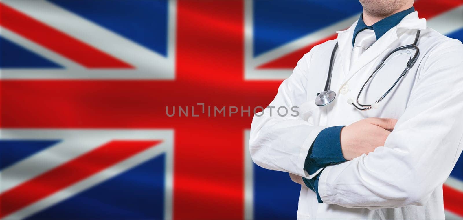 UK Health and Care concept. Professional doctor on British flag. Doctor with crossed arms on British flag.
