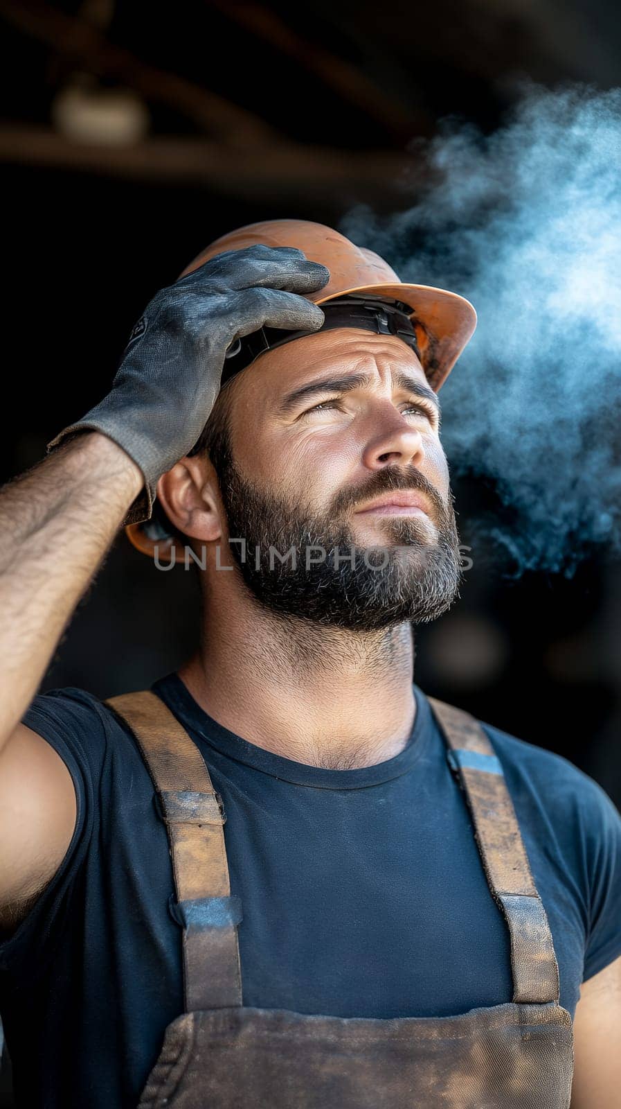 Determined construction worker in a dusty environment, wearing a hard hat and gloves, contemplating his work.