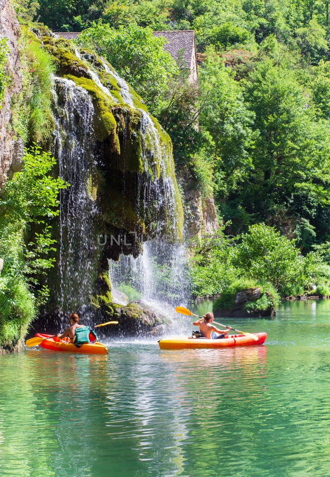 Canoes and waterfall of Saint-Chély-du-Tarn village in the valley of the Tarn river, french canyon