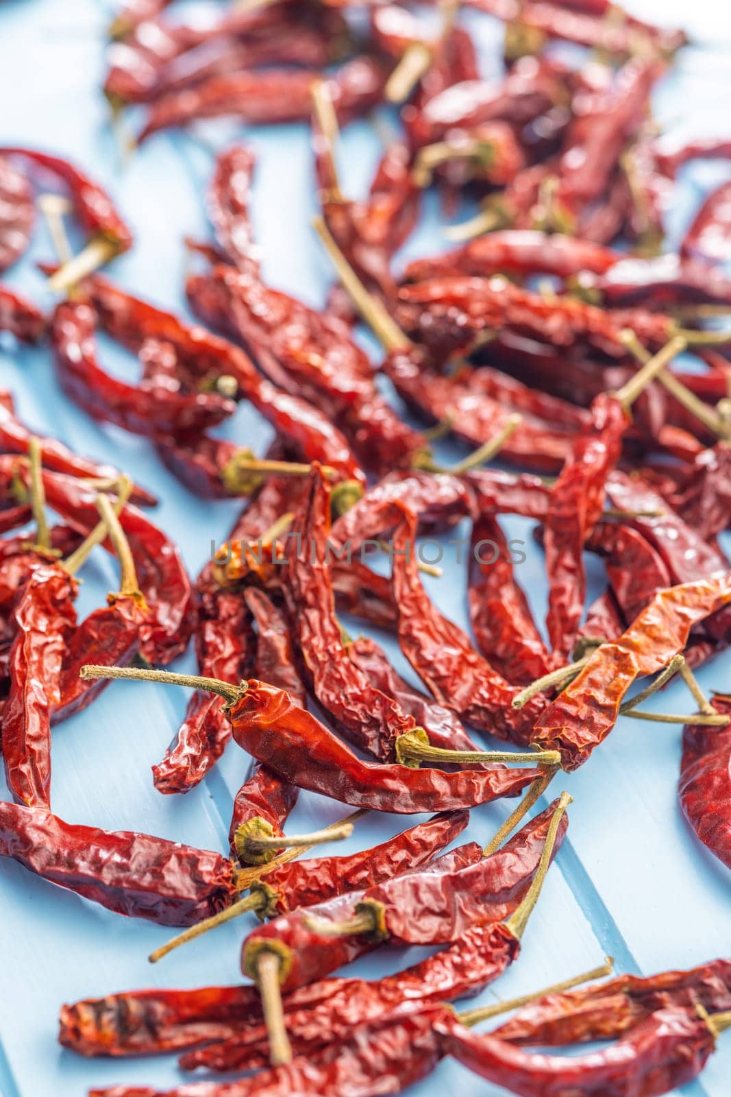 Dried red chili peppers on a blue table.