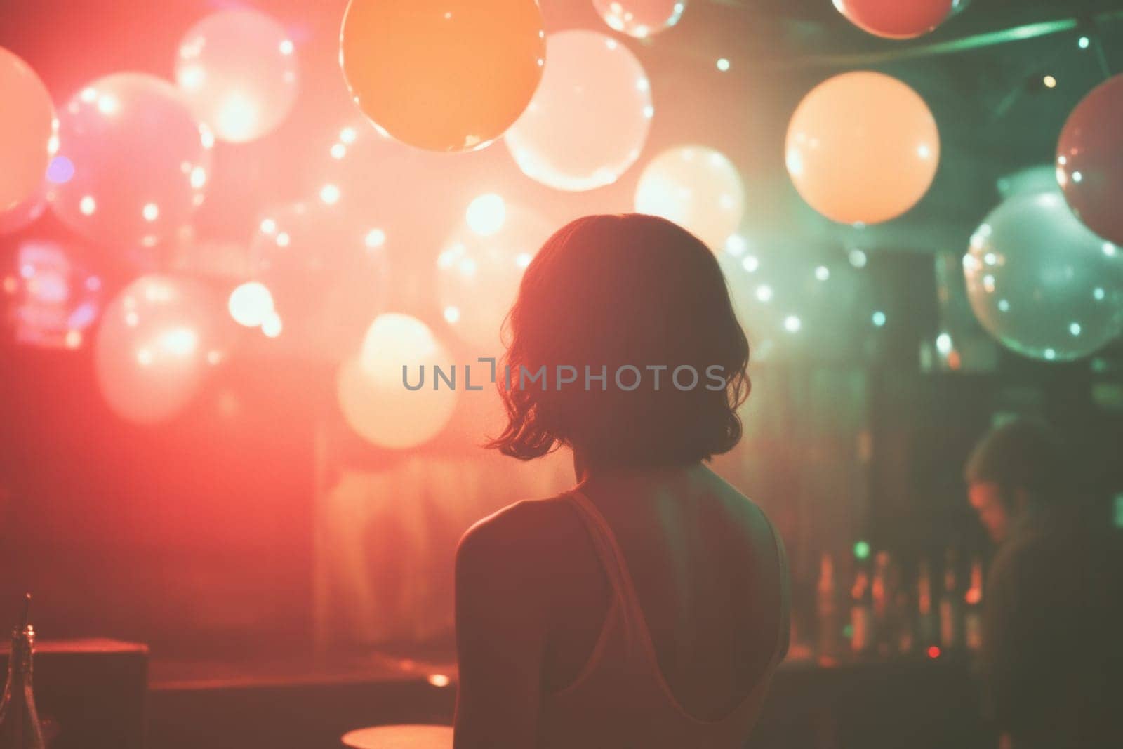 Woman is enjoying nightlife, watching party with balloons and colorful lights
